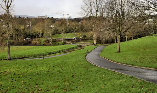 Paths winding across green lawns and trees in Moat Park, Dundonald.
